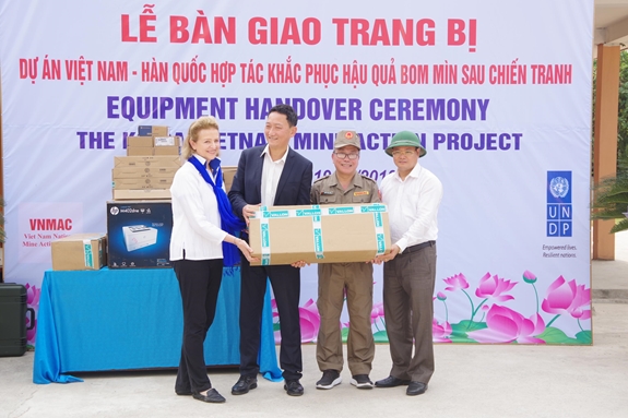 Ông Kim Do Huyn (thứ hai từ trái qua) bàn giao thiết bị rà phá bom mìn cho VNMAC.